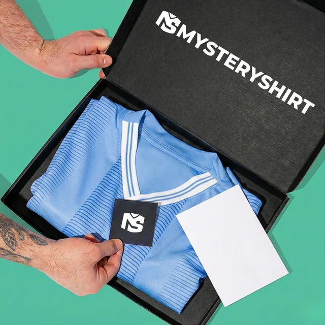 Hände öffnen eine Mysteryshirt Box mit einem hellblauen Trikot