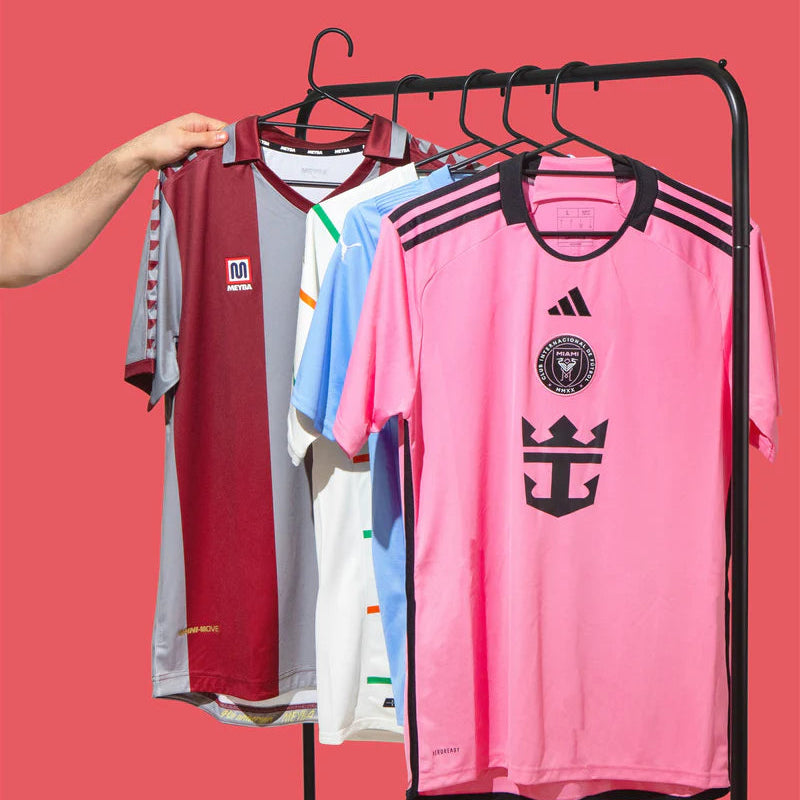 Collection of sports jerseys on a rack against a red background